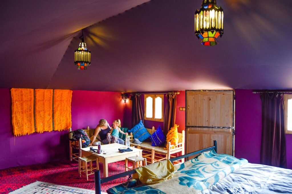 Mother and child sit inside a colourful tent at Ali & Saras Desert Palace