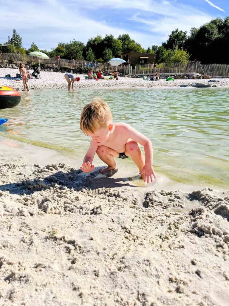 Boy plays in the sand at Castel Camping La Garangeoire lagoon