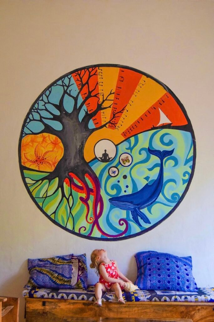 A large colourful wall mural of a tree and dolphin, in the entrance to Distant Relatives Ecolodge & Backpackers