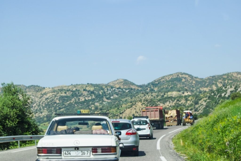 Vehicles drive along in a line on a Moroccan road.