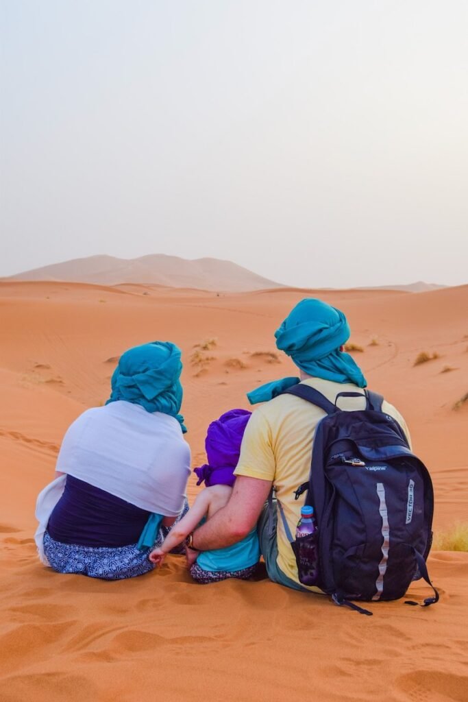 Family sit in Sahara Desert