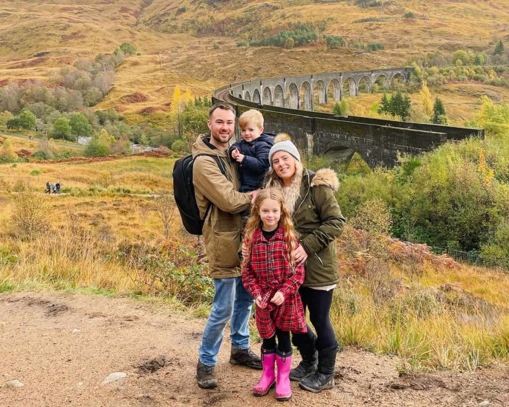 Family of four stand in front of the Glenfinnan Viaduct