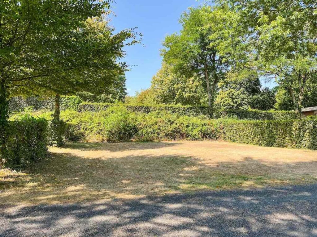 Camping pitch at  La Garangeoire, with green grass and trees.