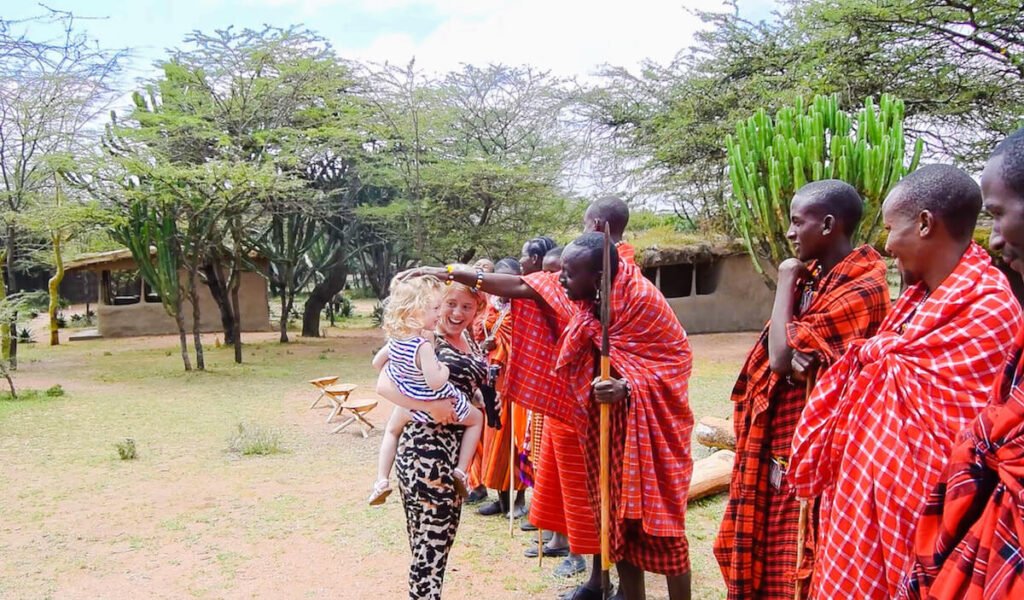 A young child and her mother meet the Maasai Tribe at Maji Moto Maasai Cultural Camp