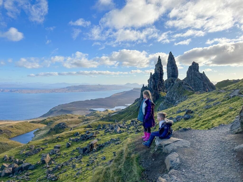 Two children stand at the top of the Old Man of Storr