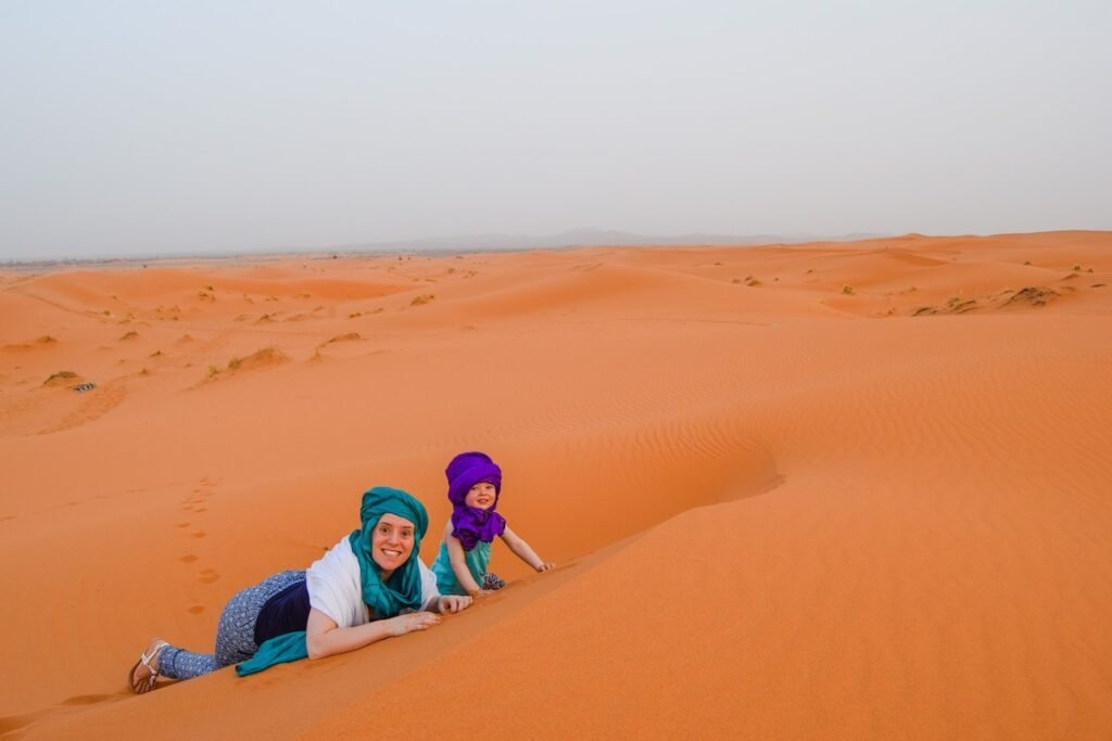 Child and mother play in the Sahara Desert