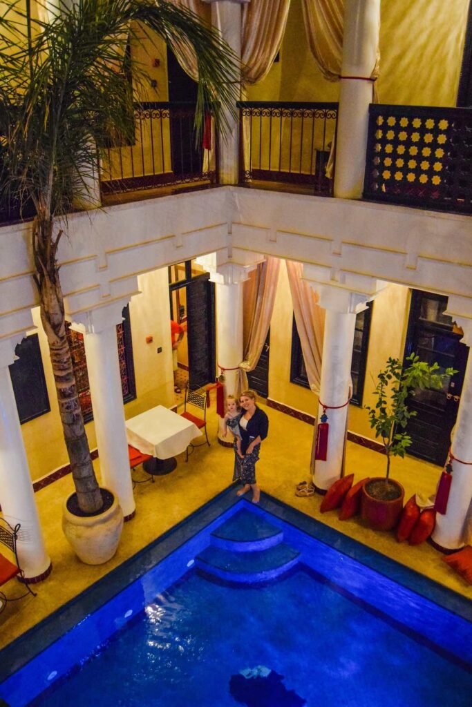 Mother and daughter stand on the edge of the centre courtyard pool at Riad Africa