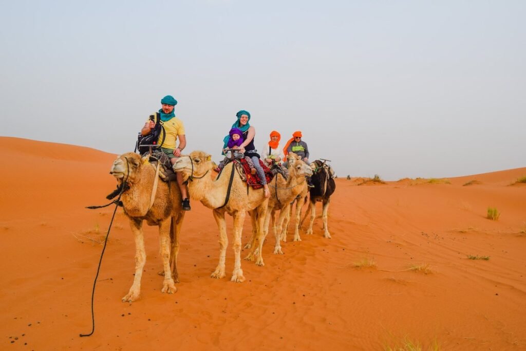 A family ride camels across the Sahara Desert