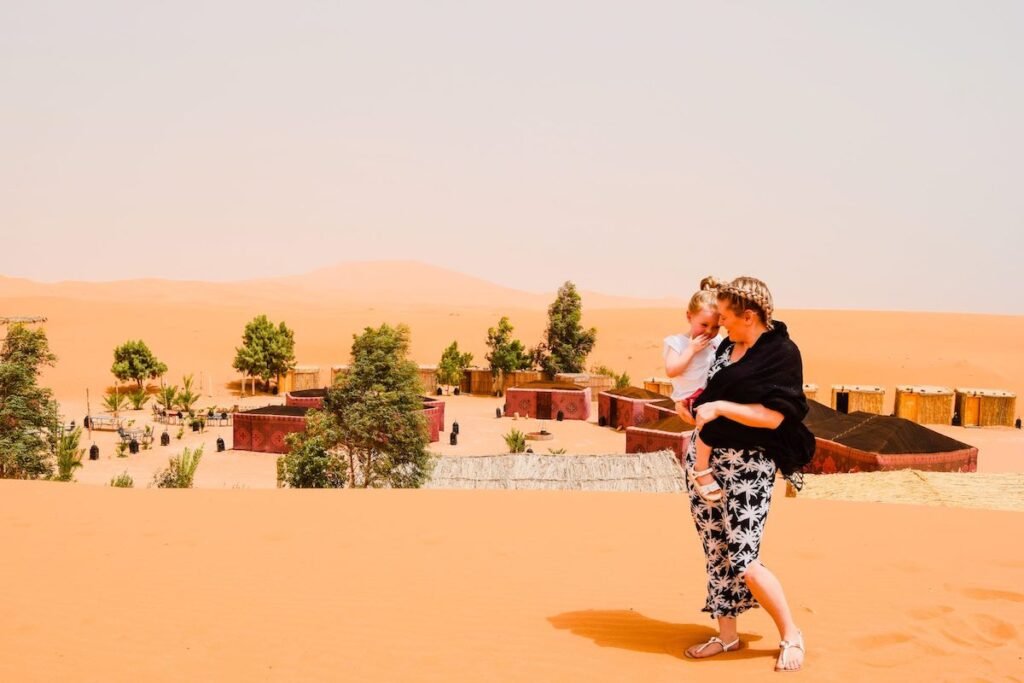 Mother and child standover looking desert camp