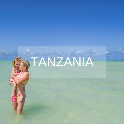 Mother and daughter stand in aqua sea in Zanzibar