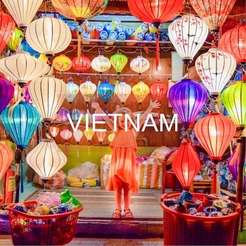 Young girl stands in Hoi An with colourful lanterns