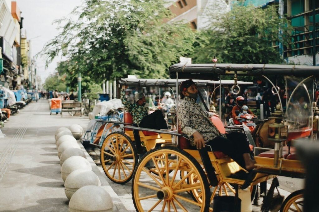 A man relaxes in a agon in a street in Yogyakarta