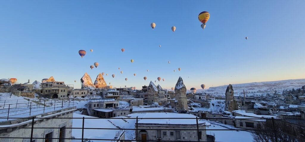 Hot air balloons flying over Cappadocia covered in snow