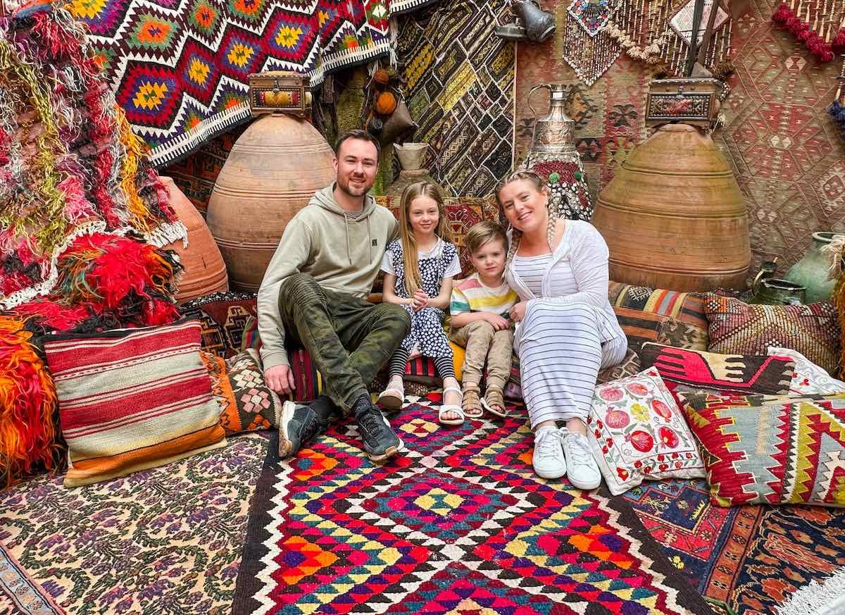 Family of four sit in Galerie Ikma in Cappadocia, a colourful carpet shop